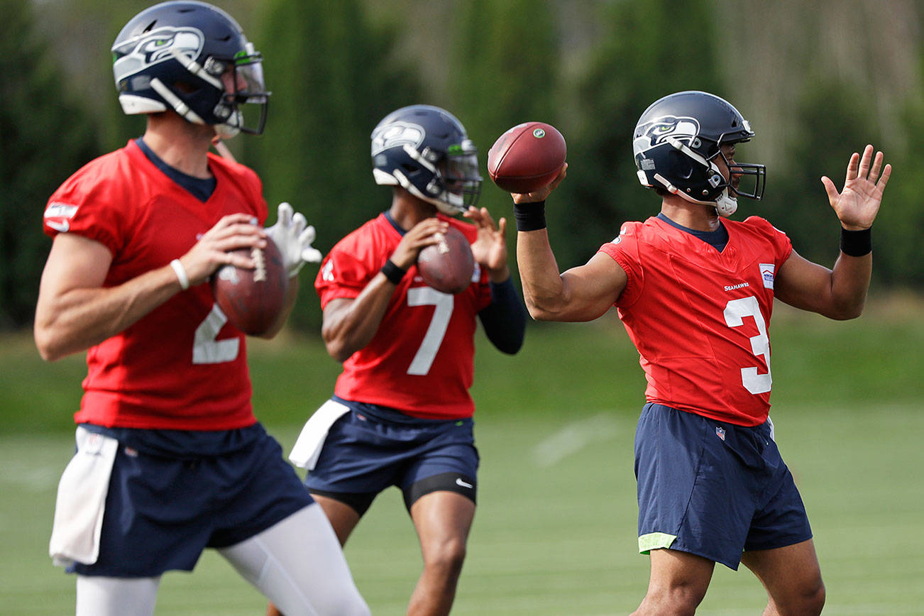 Seattle Seahawks starting quarterback Russell Wilson (3) leads Paxton Lynch (2) and Geno Smith (7) in a quarterbacks drill at an NFL football training camp Thursday, Aug. 1, 2019, in Renton, Wash. (AP Photo/Elaine Thompson)