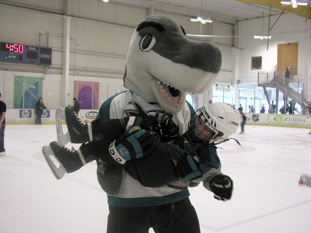 A four-year-old Dustin Wolf is scooped up by San Jose Sharks mascot “S.J. Sharkie” during a fan skate. (Photo courtesy of the Wolf family)
