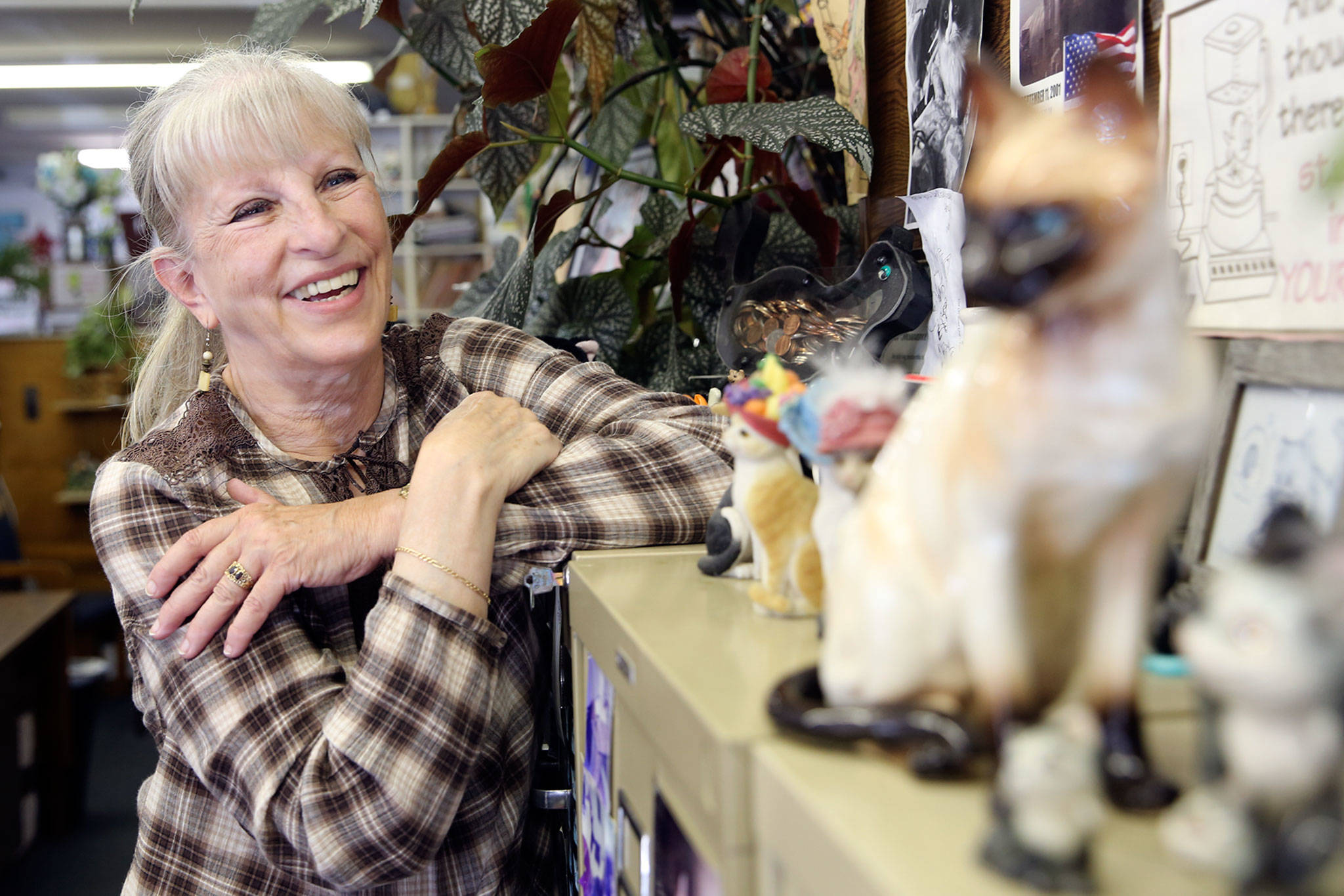 Judy Andersen of Andersen Insurance with her collection of cat figurines that dot the office space. (Kevin Clark / The Herald)