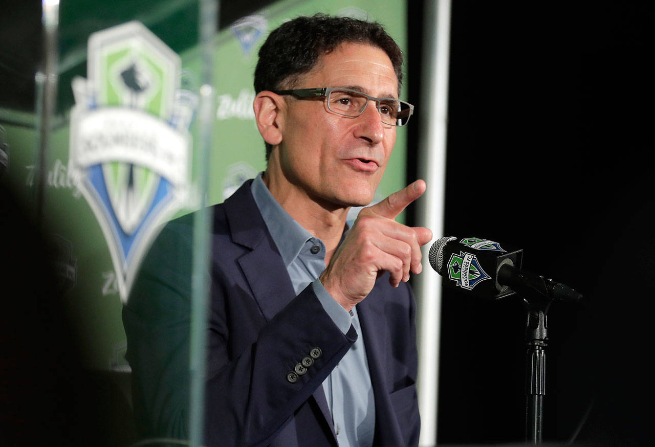 Sounders majority owner Adrian Hanauer talks to reporters on Aug. 13, 2019, in Seattle. Hanauer said Tuesday that the MLS soccer team is adding Seahawks quarterback Russell Wilson and his wife Ciara, hip-hop artist Macklemore, and Microsoft CEO Satya Nadella to the MLS club’s ownership group, along with other investors. Hollywood producer Joe Roth, who helped bring the MLS to Seattle, is leaving the franchise. (AP Photo/Ted S. Warren)