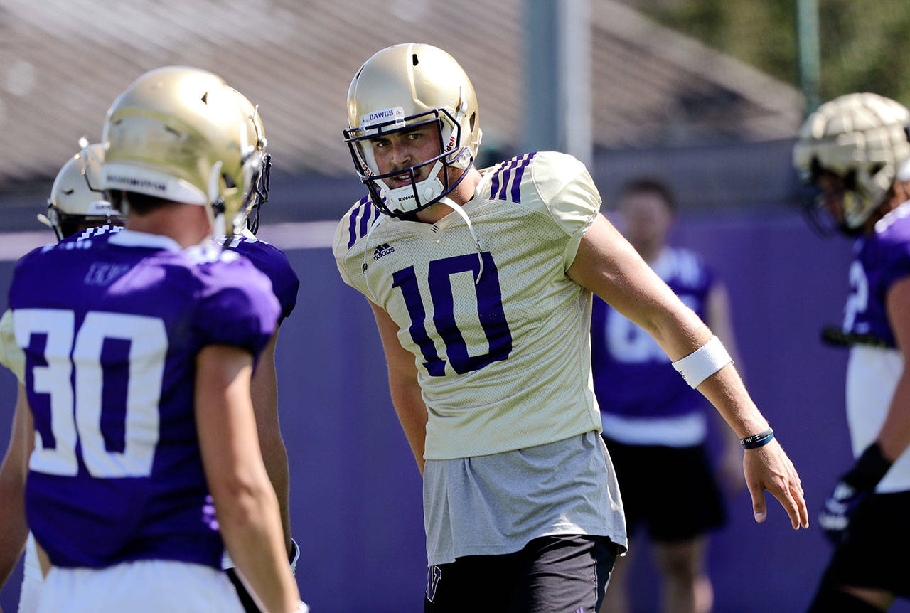 Washington quarterback Jacob Eason, a Lake Stevens alum, greets a teammate during practice on Aug. 6, 2019, in Seattle. (AP Photo/Elaine Thompson)