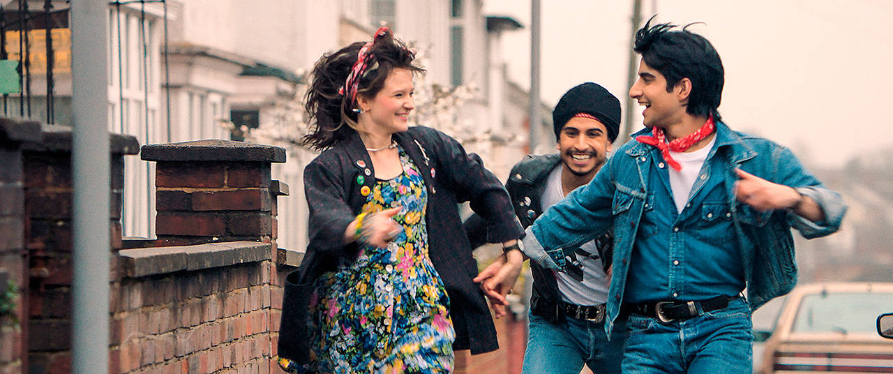 From left, Nell Williams, Aaron Phagura and Viveik Kalra exult on the streets of 1980s London in “Blinded by the Light.” (Warner Bros. Pictures)