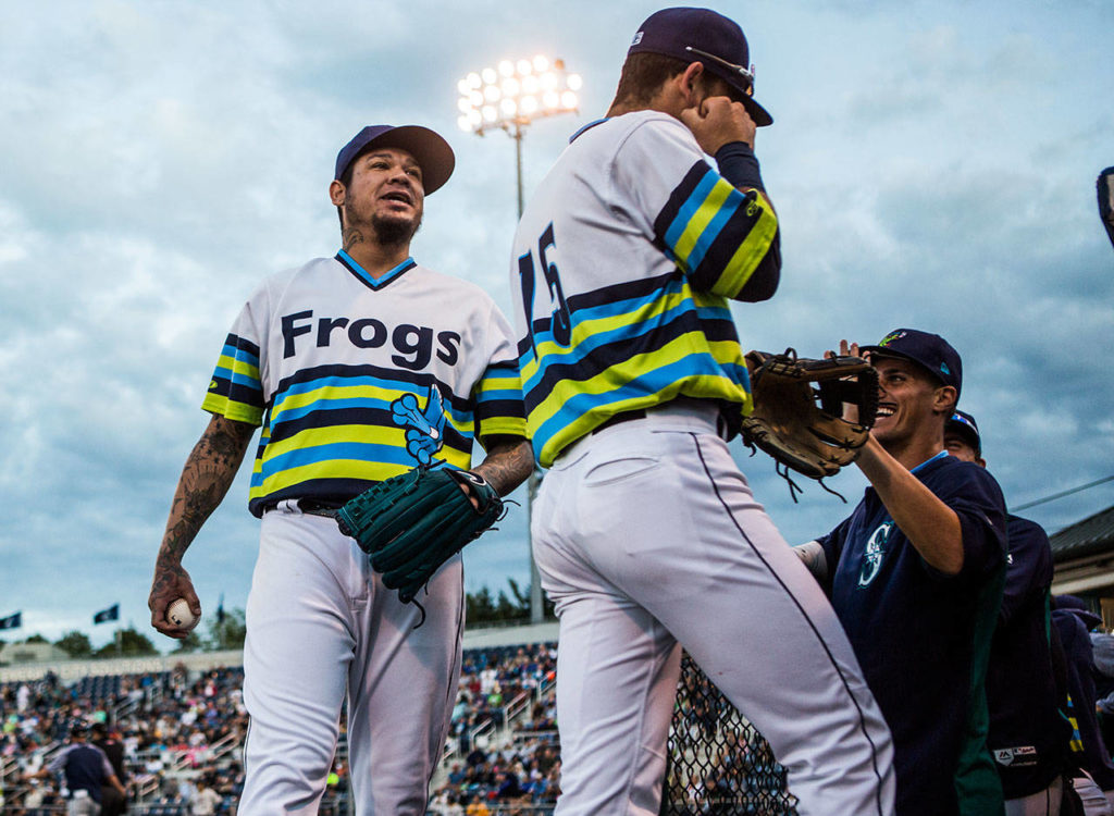 Mariners pitcher Felix Hernandez jokes with AquaSox players as he makes his way to the dugout Wednesday during a rehab appearance at Funko Field in Everett. (Olivia Vanni / The Herald)
