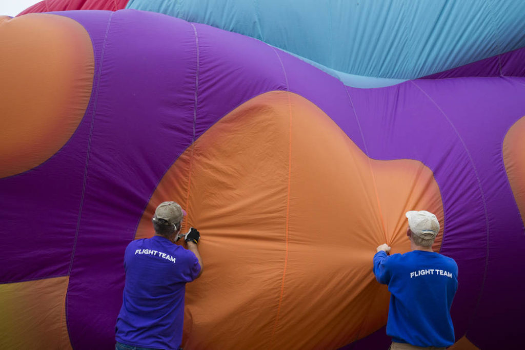 Ballooning Snohomish flight crew Dwayne Osborne (left) and Drew Cameron grab fabric as they help inflate the balloon named Betty Jean at Arlington Municipal Airport on Friday in Arlington. (Andy Bronson / The Herald)
