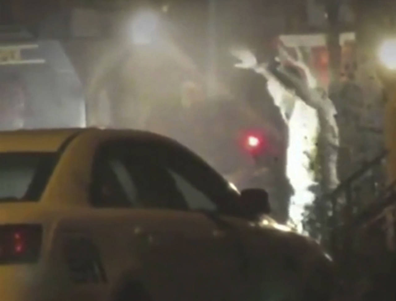 In this image from video, a man exits a building with hands up in Philadelphia, Pennsylvania. A gunman who opened fire on police Wednesday as they were serving a drug warrant in Philadelphia, wounding six officers and triggering a standoff that extended into the night, is in police custody, authorities said. (Bill Trenwith via AP)