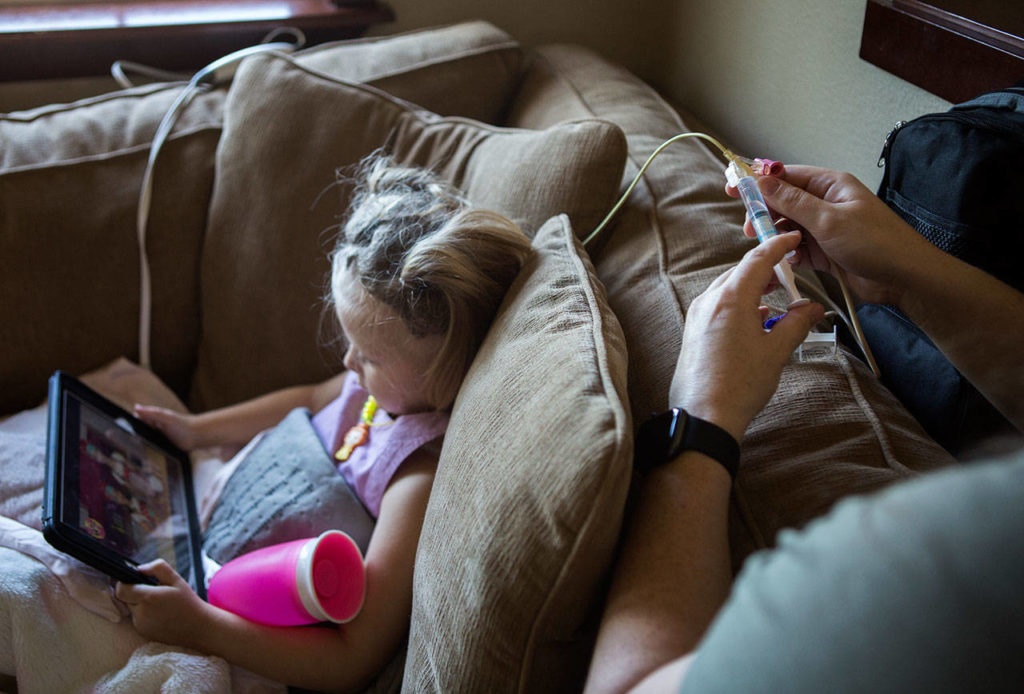 Sadie Sheldon watches YouTube Kids as her mother administers her a nausea medicine, which she gets every six hours. (Olivia Vanni / The Herald)
