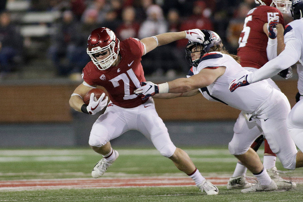 Washington State running back Max Borghi (21) fends off the tackle of Arizona linebacker Colin Schooler during a game on Nov. 17, 2018, in Pullman. (AP Photo/Young Kwak)