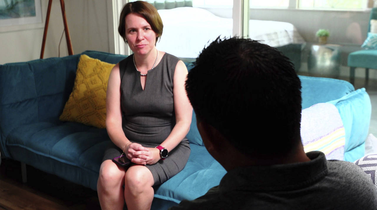 In this Aug. 7 image made from video, attorney Michelle Lapointe speaks with her client, a Guatemalan immigrant, in Santa Ana, California. The father is preparing to sue the federal government, alleging his 8-year-old boy was sexually molested in a foster care home funded by the U.S. Health and Human Services agency. (AP Photo/Krysta Fauria)
