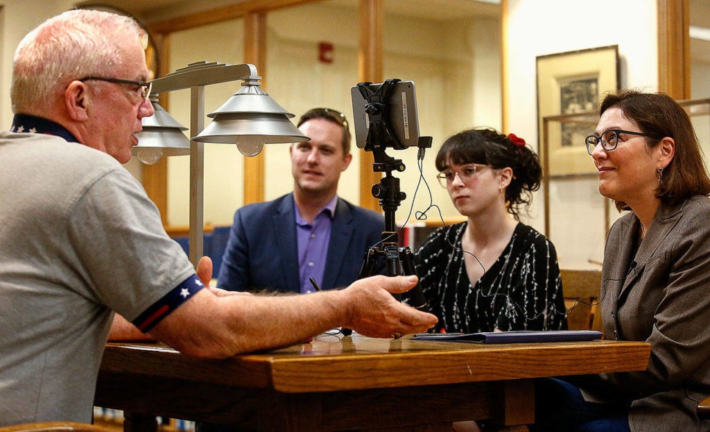 Otis Wolfe, (left), who served aboard a Navy ship during the Vietnam War, tells his story to Congresswoman Suzan DelBene who is watching him on a live recording on an iPad Mini) as summer intern Kyra Shelton and Benjamin Studley listen and assist. Studley is DelBene’s veterans liaison. (Dan Bates / The Herald)
