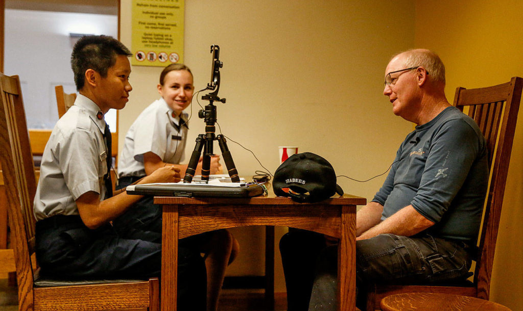 Jay Bonner tells interviewers Randolph Halim, 15, (left) and Karolina Dubiel, 14, about his duty with the Seabees, which took him to the Camp David Presidential retreat for two years. (Dan Bates / The Herald)
