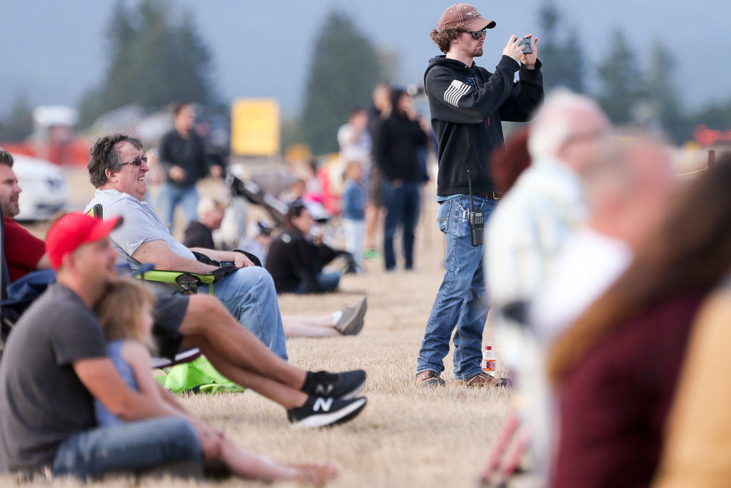 Spectators enjoy the Arlington Fly-in at Arlington Municipal Airport on Friday evening. (Kevin Clark / The Herald)
