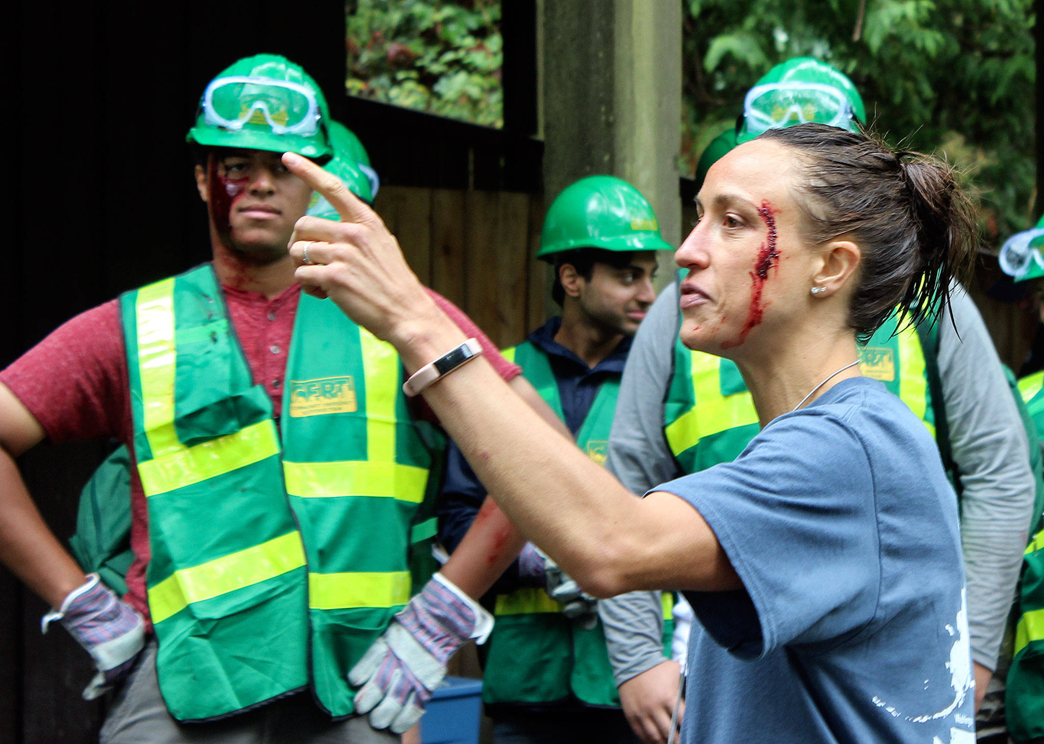 Chelsea Treboniak talks to teens about their next activity. Fake blood on her face is from an earlier lesson Wednesday at Camp Killoqua in Stanwood. (Stephanie Davey / The Herald)