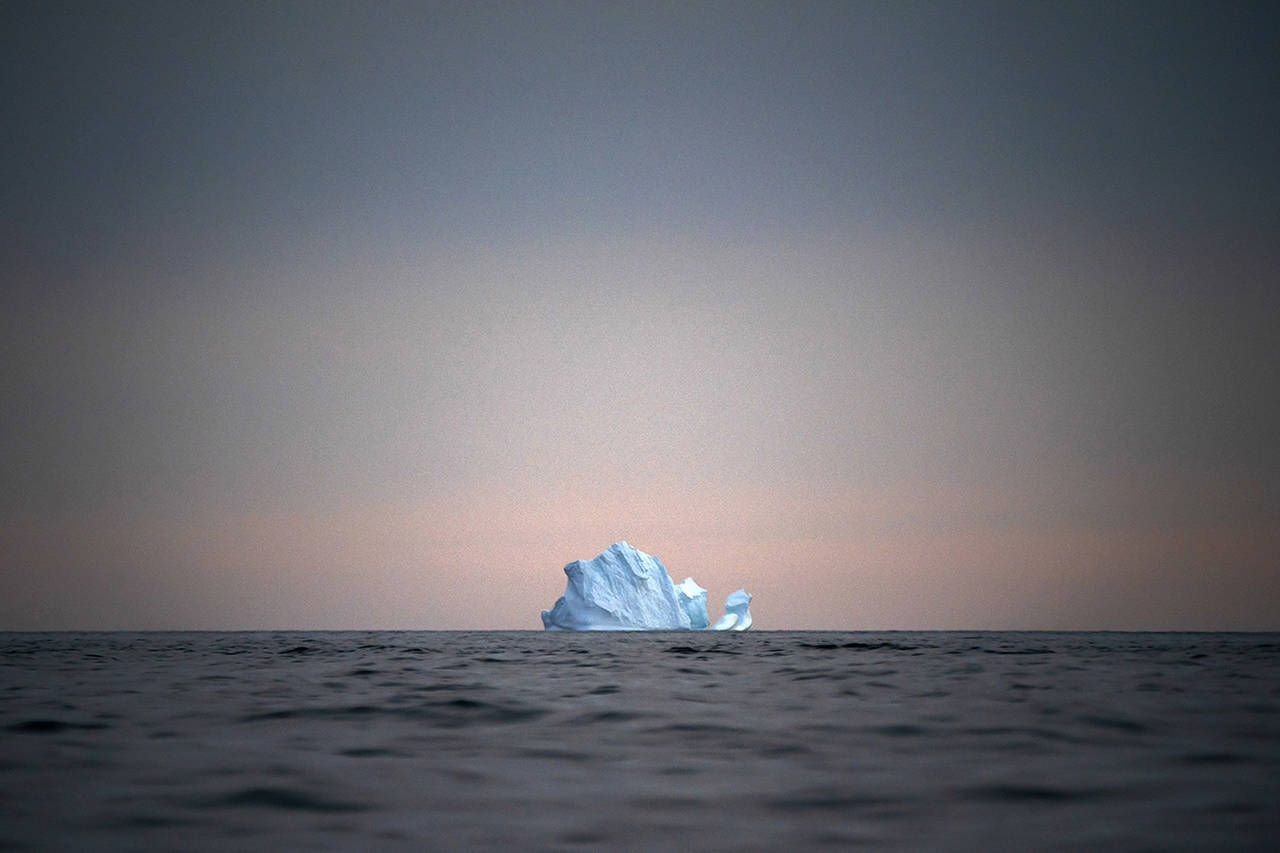 In this Aug. 15 photo, a large Iceberg floats away as the sun sets near Kulusuk, Greenland. Scientists are hard at work there, trying to understand the alarmingly rapid melting of the ice. (AP Photo/Felipe Dana)