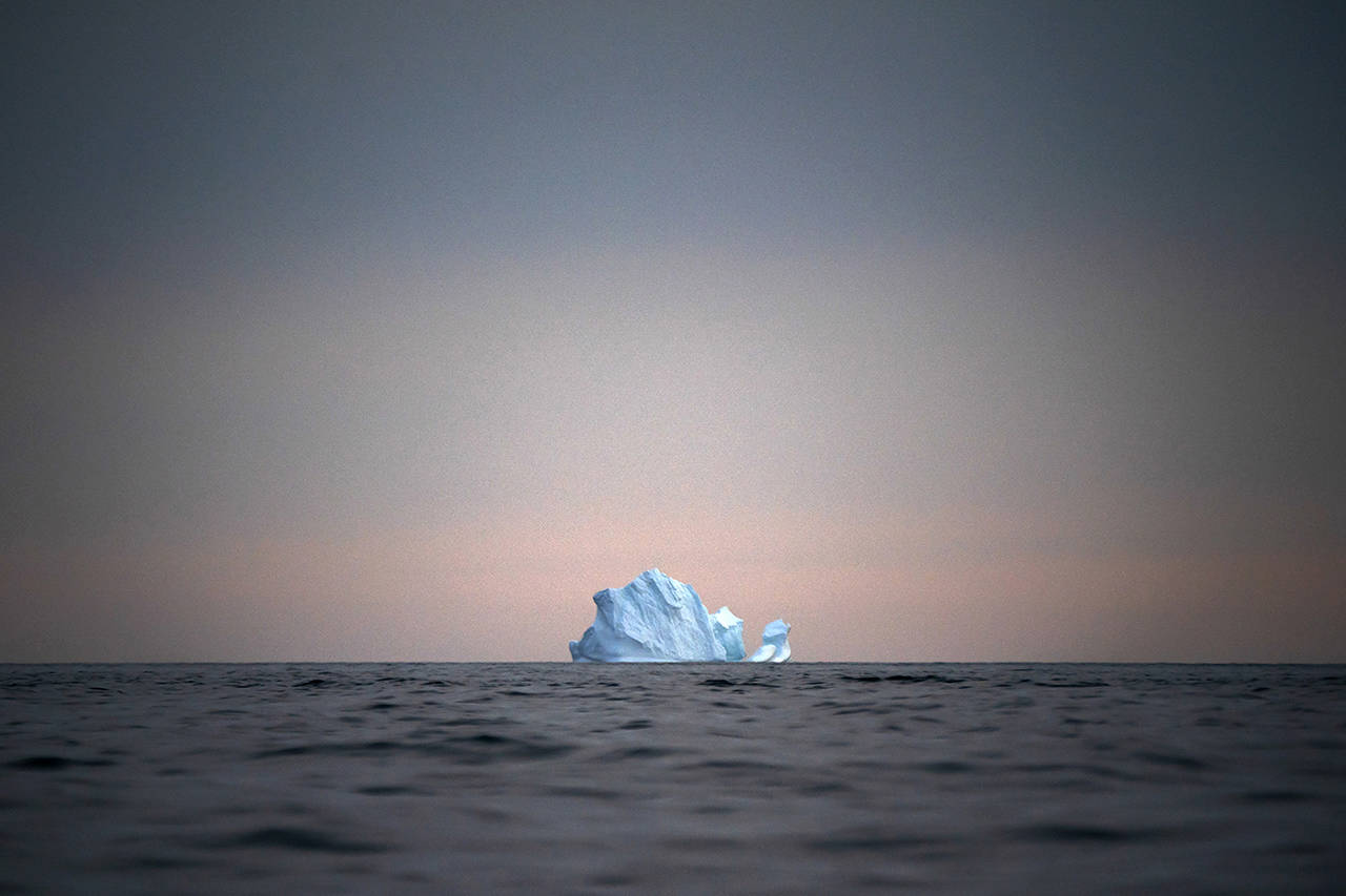 In this Aug. 15 photo, a large Iceberg floats away as the sun sets near Kulusuk, Greenland. Scientists are hard at work there, trying to understand the alarmingly rapid melting of the ice. (AP Photo/Felipe Dana)