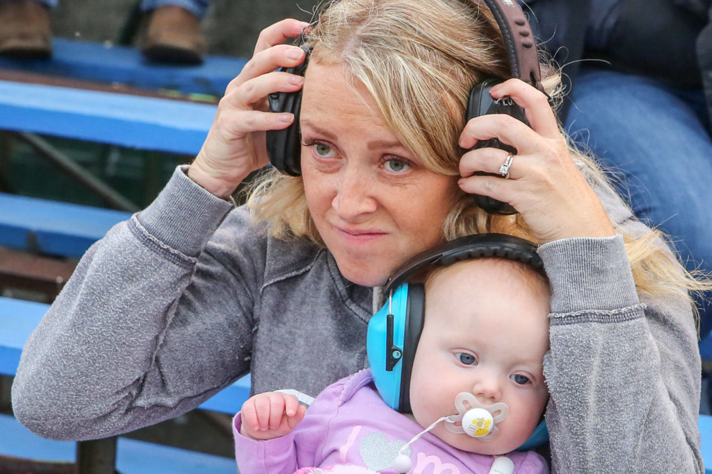 A fan dons ear protection for the high-octane entertainment of the monster truck show Friday evening during the Evergreen State Fair at the Evergreen Speedway in Monroe. (Kevin Clark / The Herald)
