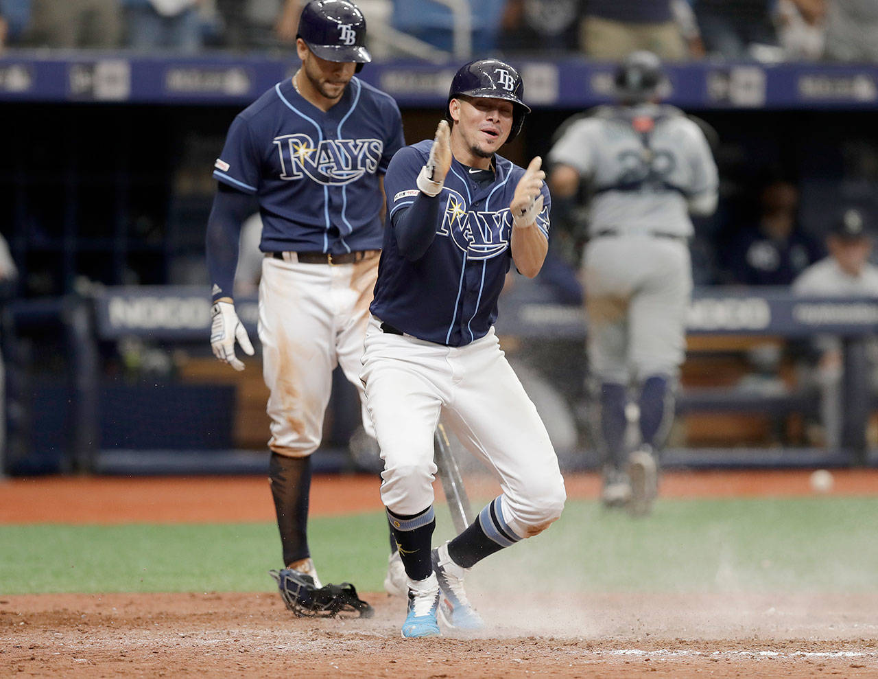 Tampa Bay’s Willy Adames (front) reacts to scoring the game-winning run on a wild pitch by Seattle’s Matt Magill during the ninth inning Wednesday in St. Petersburg, Florida, as Tommy Pham looks on. (AP Photo/Chris O’Meara)