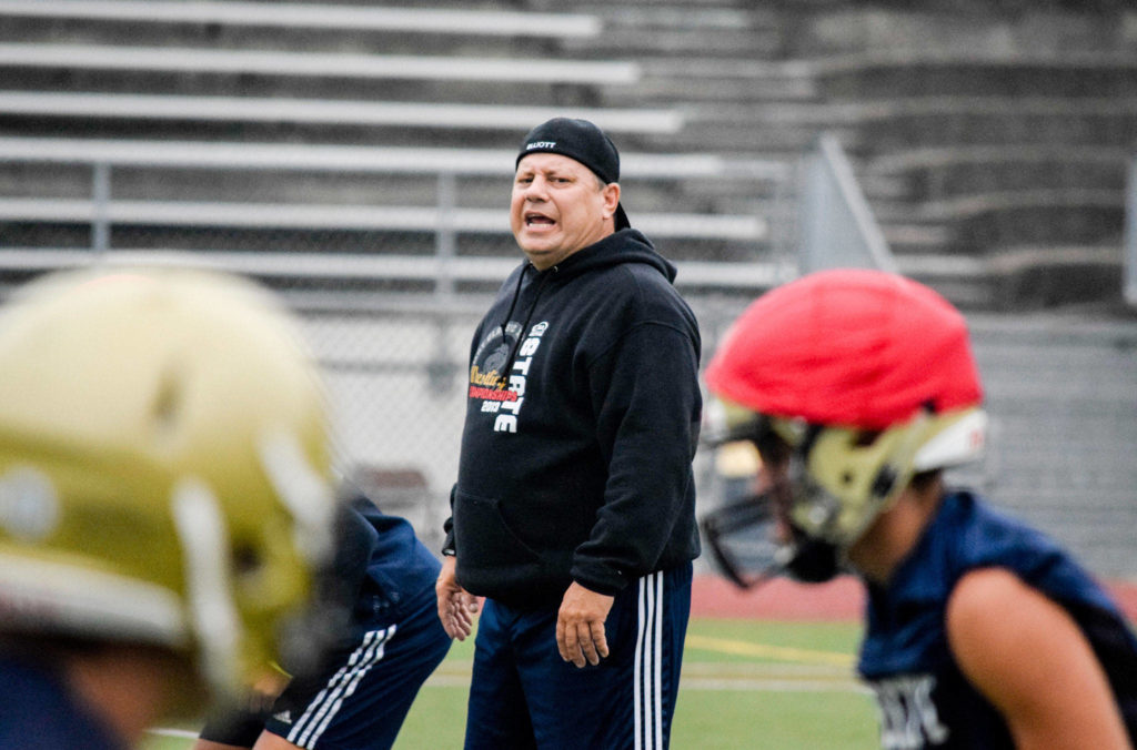 Everett’s first-year head coach, Brien Elliott, participates in his team’s seven-on-seven drills at Everett Memorial Stadium on Wednesday, Aug. 21. (Katie Webber / The Herald)
