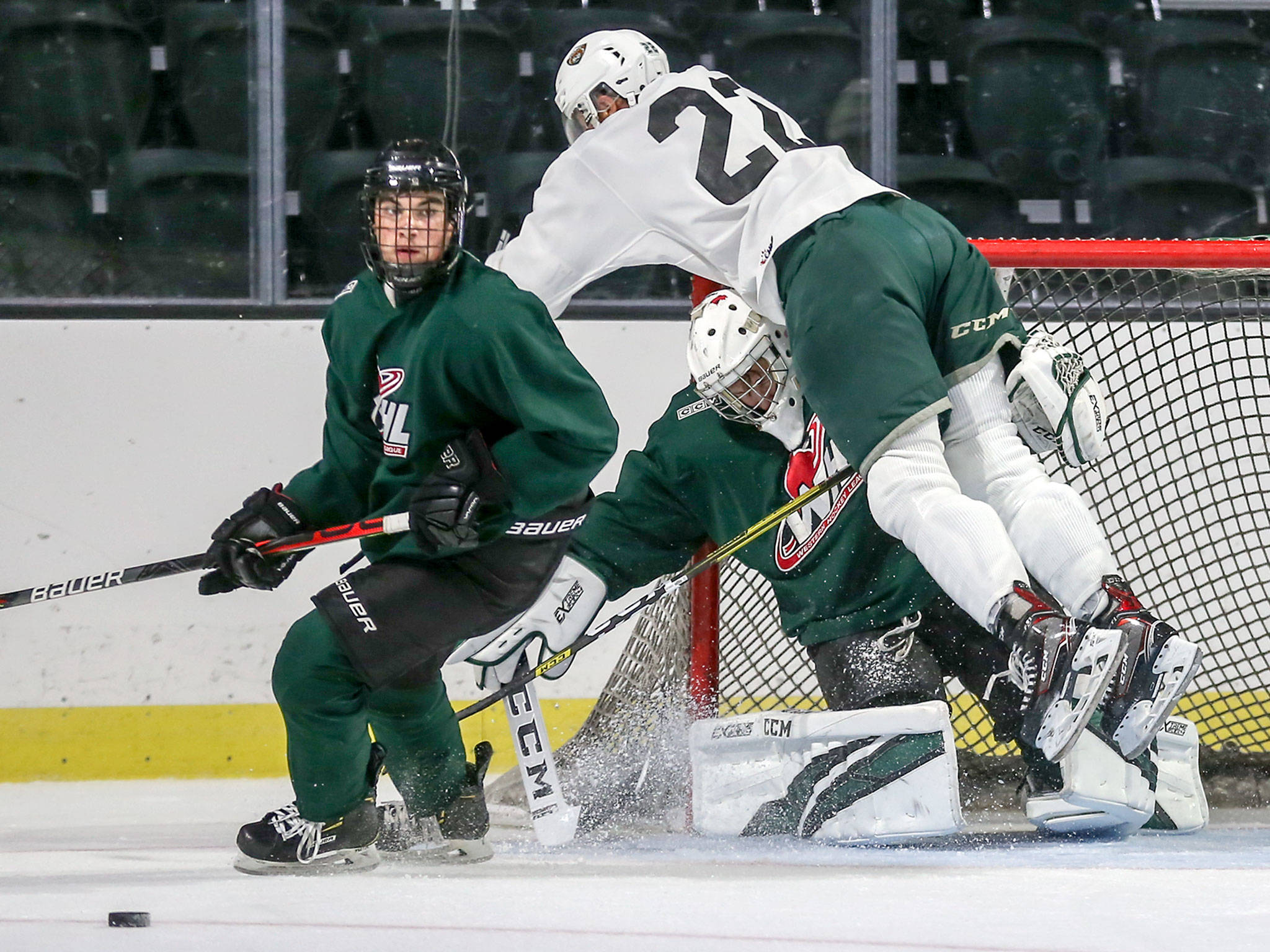 Justyn Gurney (top) crashes into goalie Evan May with Adam Bourgeois (left) looking down during Silvertips training camp on Aug. 22, 2019, at Angel of the Winds Arena in Everett. (Kevin Clark / The Herald)