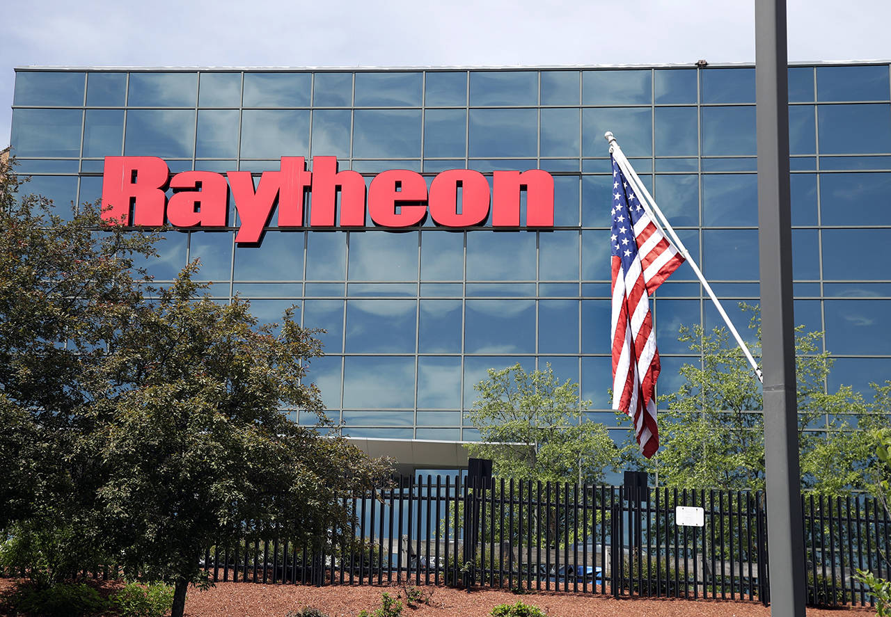A flag flies in front of the facade of Raytheon’s Integrated Defense Systems facility June 10 in Woburn, Massachusetts. (AP Photo/Elise Amendola)