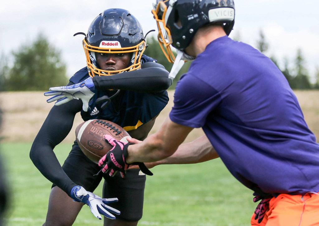 Mariner’s Muhammad Barrow (left) gets a hand-off from Jackson Cole during practice on Aug. 22, 2019, at Mariner High School in Everett. (Kevin Clark / The Herald)
