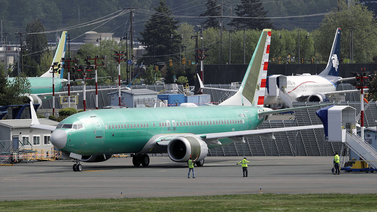 In this May 8 photo, workers stand near a Boeing 737 MAX 8 jetliner being built for American Airlines prior to a test flight in Renton. (AP Photo/Ted S. Warren, File)