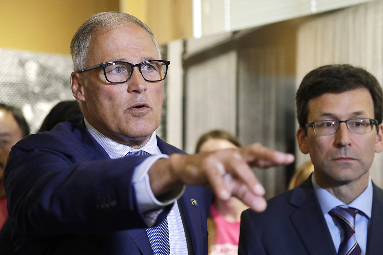 Gov. Jay Inslee (left) addresses a news conference addressing a change in rules on the nearly 50-year-old Title X family planning program as Washington Attorney General Bob Ferguson looks on Aug. 22 in Seattle. (AP Photo/Elaine Thompson)