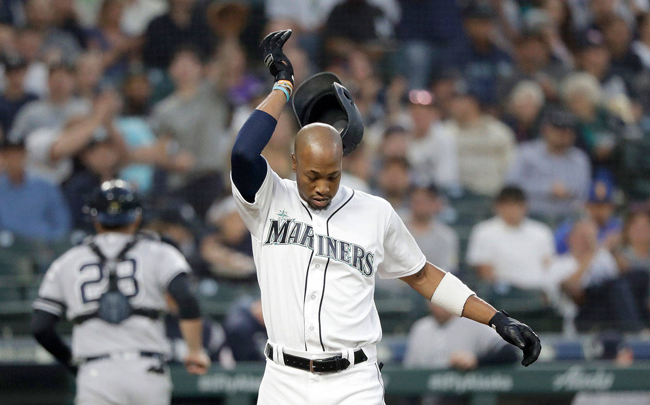 Seattle’s Keon Broxton (foreground) knocks his helmet off after striking out looking, as Yankees catcher Austin Romine heads to the dugout in the second inning the Mariners’ 5-4 loss on Monday in Seattle. Broxton was ejected for arguing the called third strike. (AP Photo/Elaine Thompson)