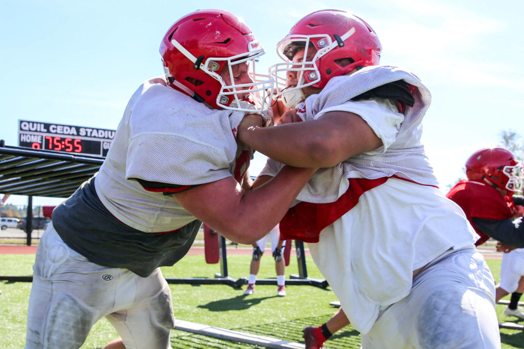 Marysville Pilchuck’s Justin Albee (left) crashes with Lukas Ramos during practice on Aug. 28, 2019, at Quil Ceda Stadium in Marysville. (Kevin Clark / The Herald)
