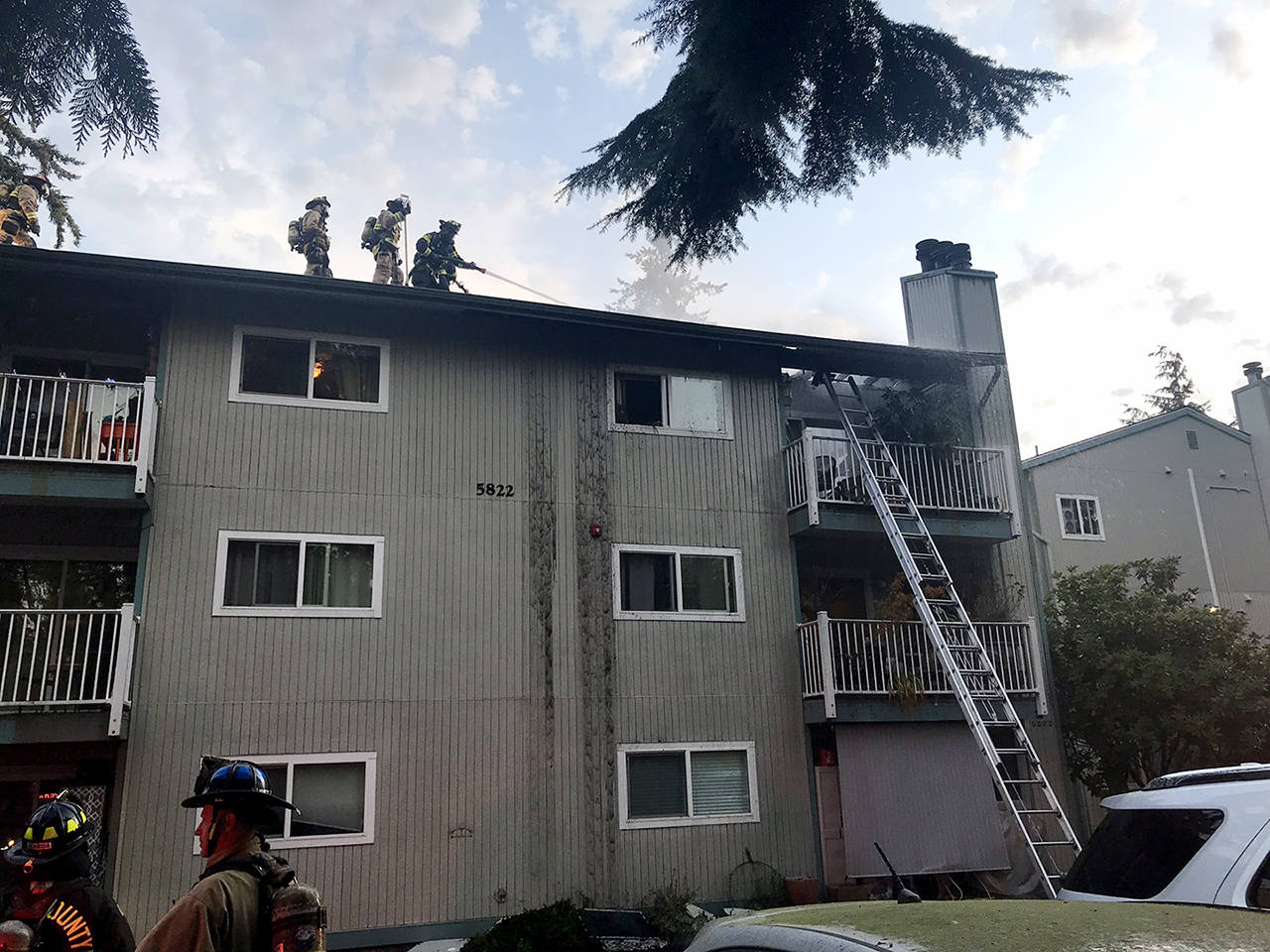 Crews spray water on the top floor of a condominium building in Lynnwood on Thursday. (South County Fire)