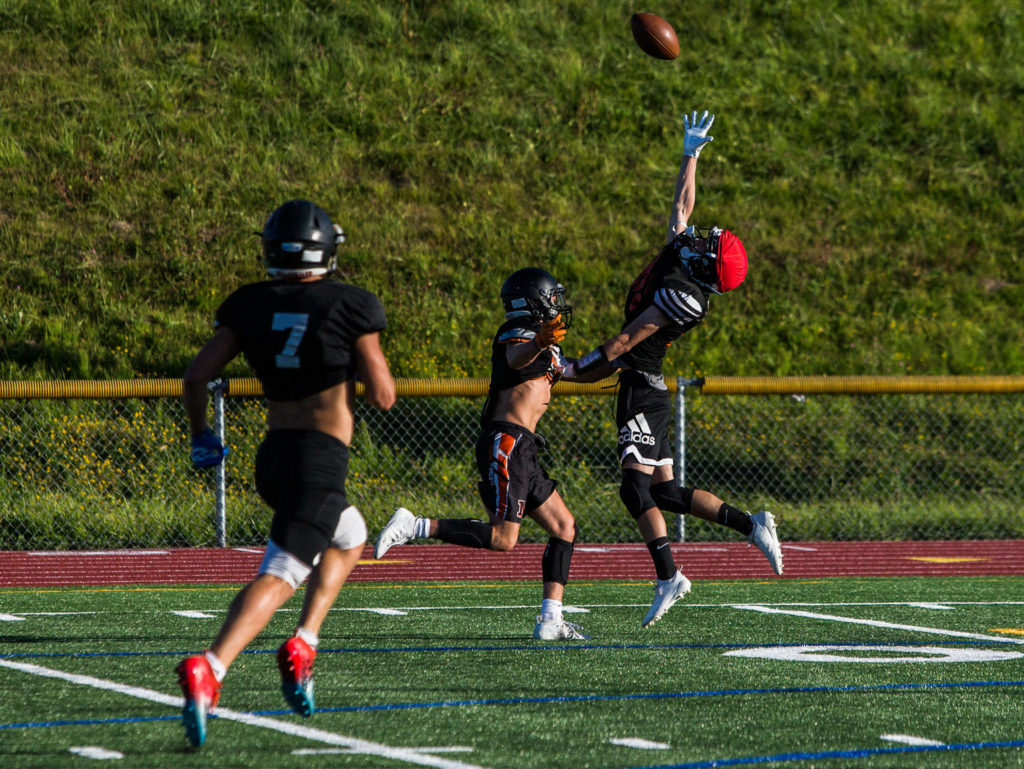 A player jumps for a pass during football practice at Monroe High School on Wednesday, Aug. 28, 2019 in Monroe, Wash. (Olivia Vanni / The Herald)

