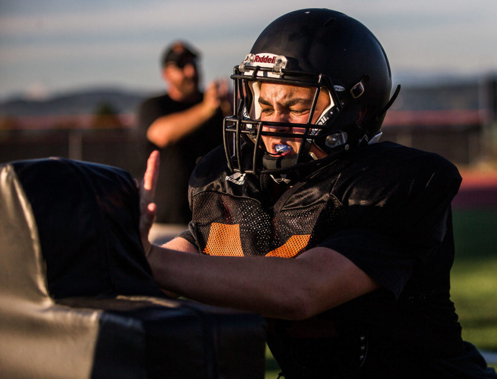 Derrick Hensley punches a pad during football practice at Monroe High School on Wednesday, Aug. 28, 2019 in Monroe, Wash. (Olivia Vanni / The Herald)
