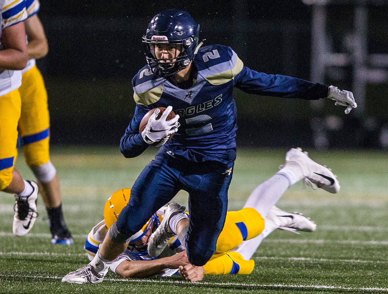 Arlington’s Bryce Petersen escapes a tackle during the game on Sept. 21, 2018 in Arlington. (Olivia Vanni / The Herald)