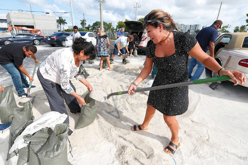 Georgia Bernard (right) and Ana Perez are among residents filling sandbags to take home in preparation for Hurricane Dorian, Friday in Hallandale Beach, Florida, as the town allowed residents to fill up sandbags until they ran out. All of Florida is under a state of emergency and authorities are urging residents to stockpile a week’s worth of food and supplies as Hurricane Dorian gathers strength and aims to slam the state as soon as Monday as a Category 4 storm. (AP Photo/Wilfredo Lee)
