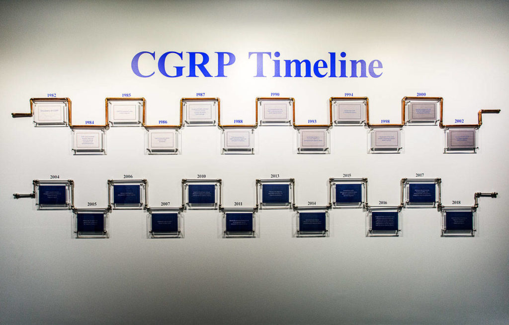 A timeline of the development of the Alder Biopharmaceuticals drug Eptinezumab is displayed in a hallway at the company labs in Bothell. (Olivia Vanni / The Herald) 
