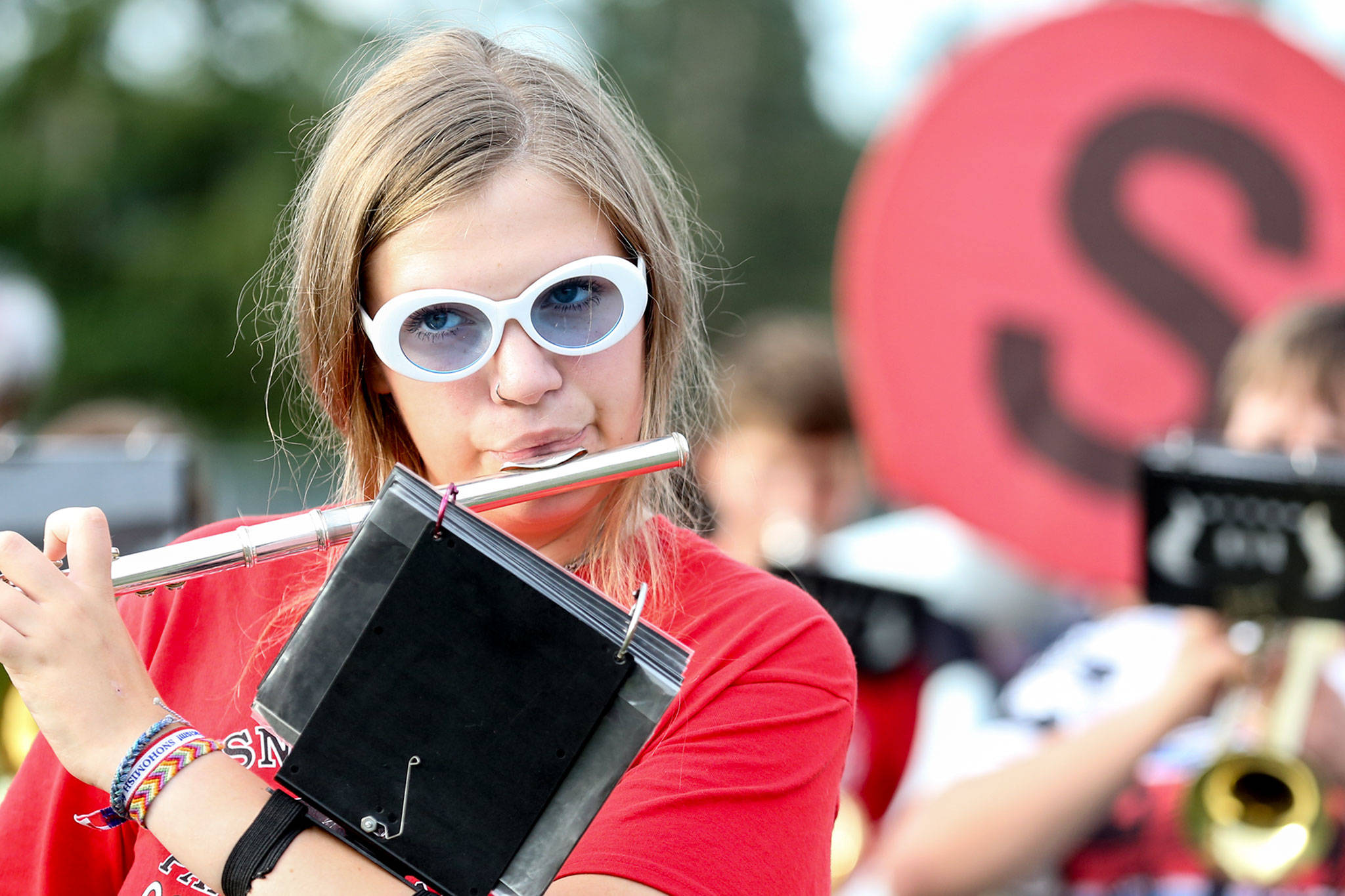 Camlin Vespaz plays her flute during practice Thursday evening at Snohomish High, in preparation for the first football game of the season. (Kevin Clark / The Herald)