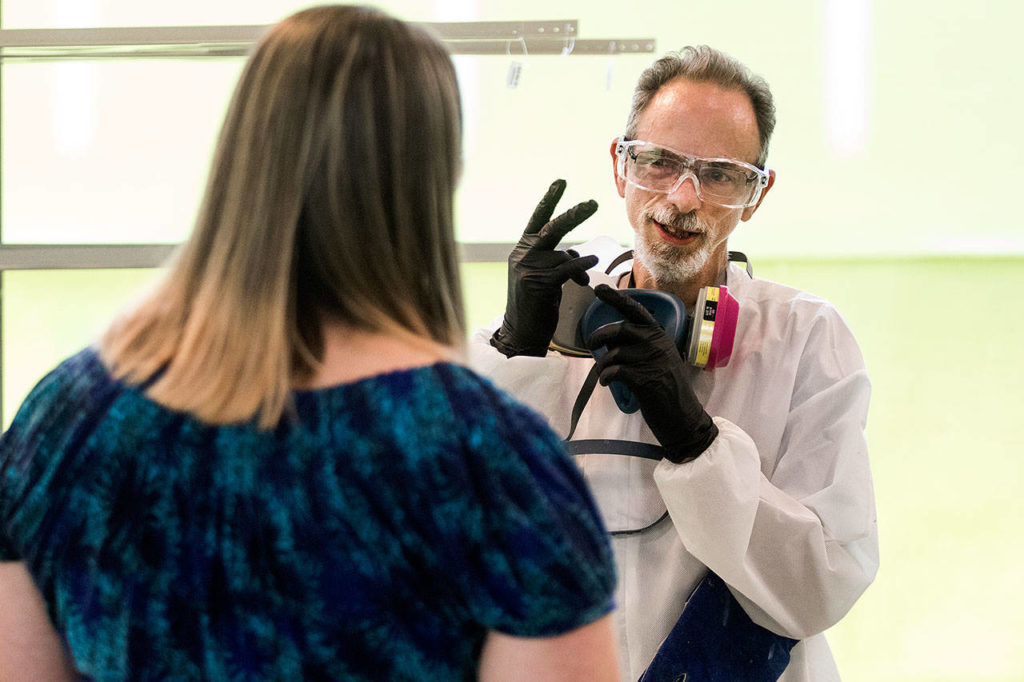 Daniel Haistings, who is deaf, and Human Resource Manager Jasmin Baker-Kinney use American Sign Language at Valence Surface Technologies in Everett. (Andy Bronson / The Herald)
