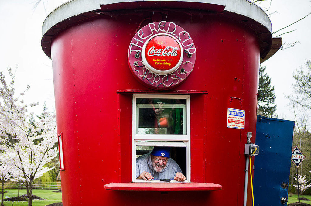 Ron Nardone peeks out the window of a coffee stand in the shape of a giant red coffee cup. It’s one of many unique structures at NardoLand. (Olivia Vanni / The Herald)
