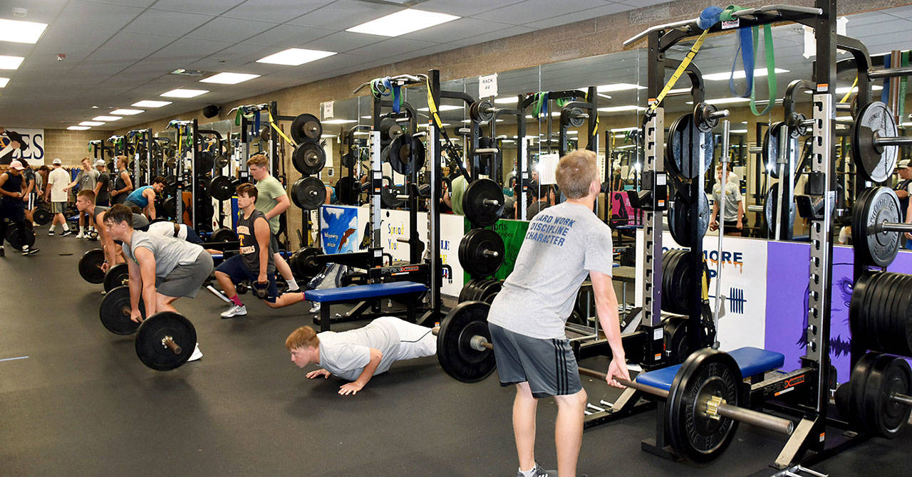 Arlington High School football players lift weights in the school gym. New weight cages have been installed at the school over the past four years thanks to donations from the Stillaguamish and Tulalip tribes. (Arlington Public Schools)