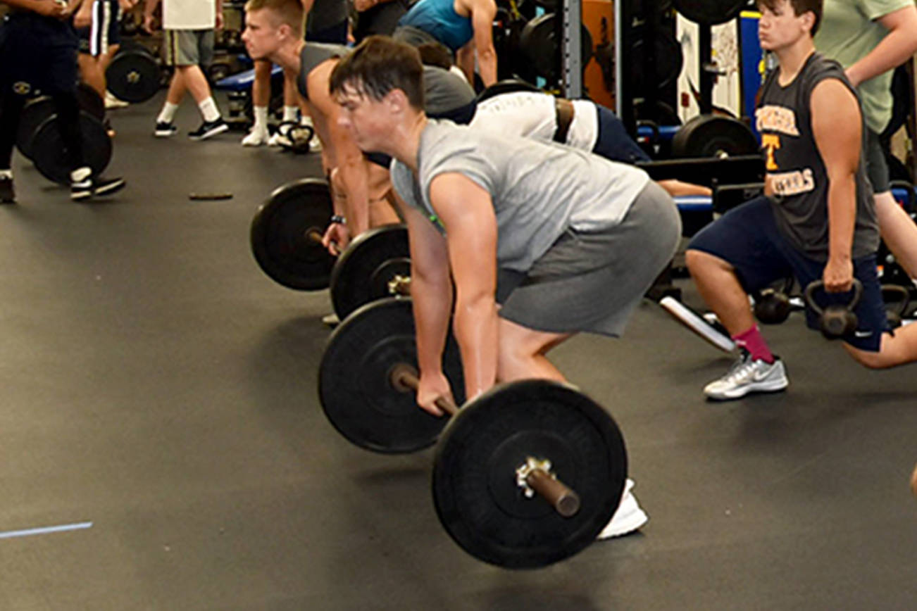 Arlington High School football players lift weights in the school gym. New weight cages have been installed at the school over the past four years thanks to donations from the Stillaguamish and Tulalip tribes. (Arlington Public Schools)