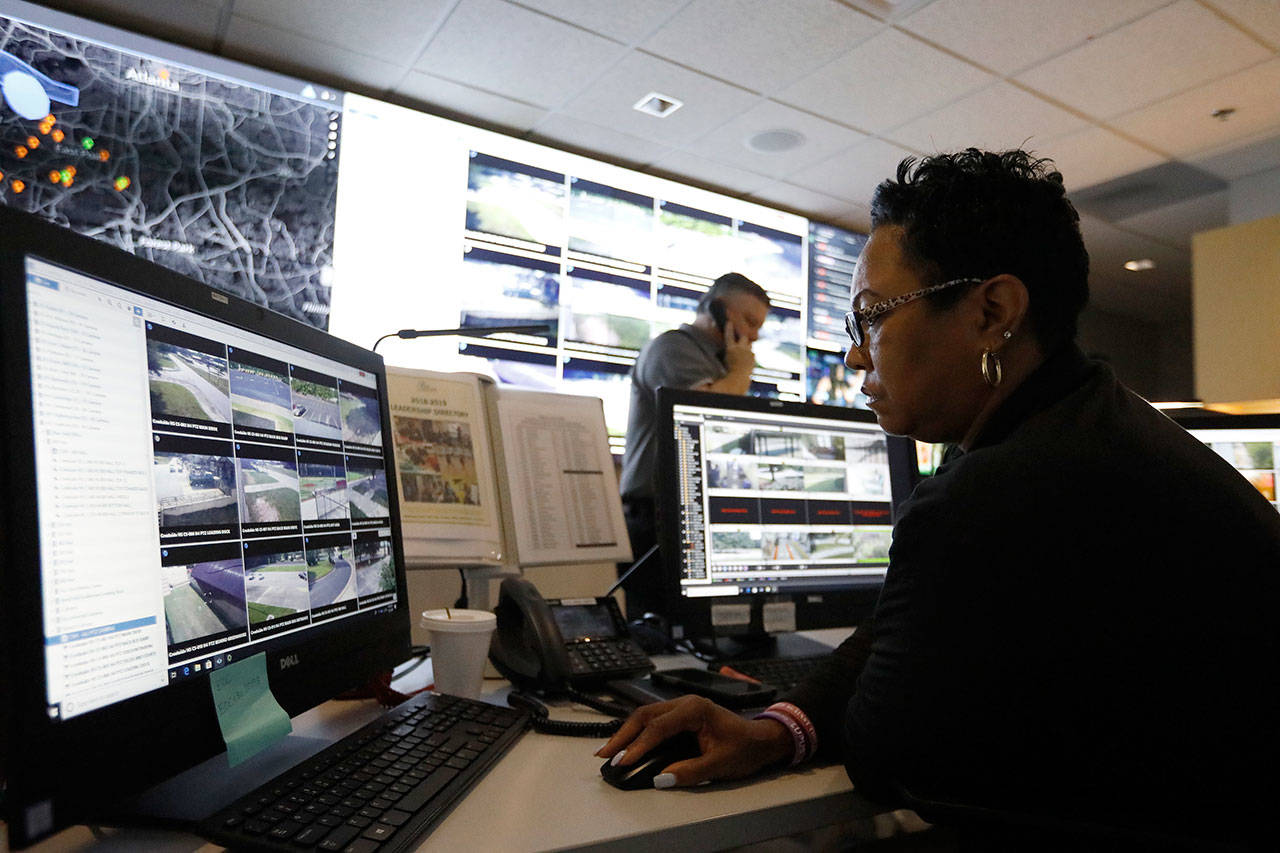 Sandra Swint, campus security associate for Fulton County School District and Paul Hildreth (background), the district’s emergency operations coordinator, work in the emergency operations center at the Fulton County Schools Administration Center in Atlanta. (AP Photo/Cody Jackson)