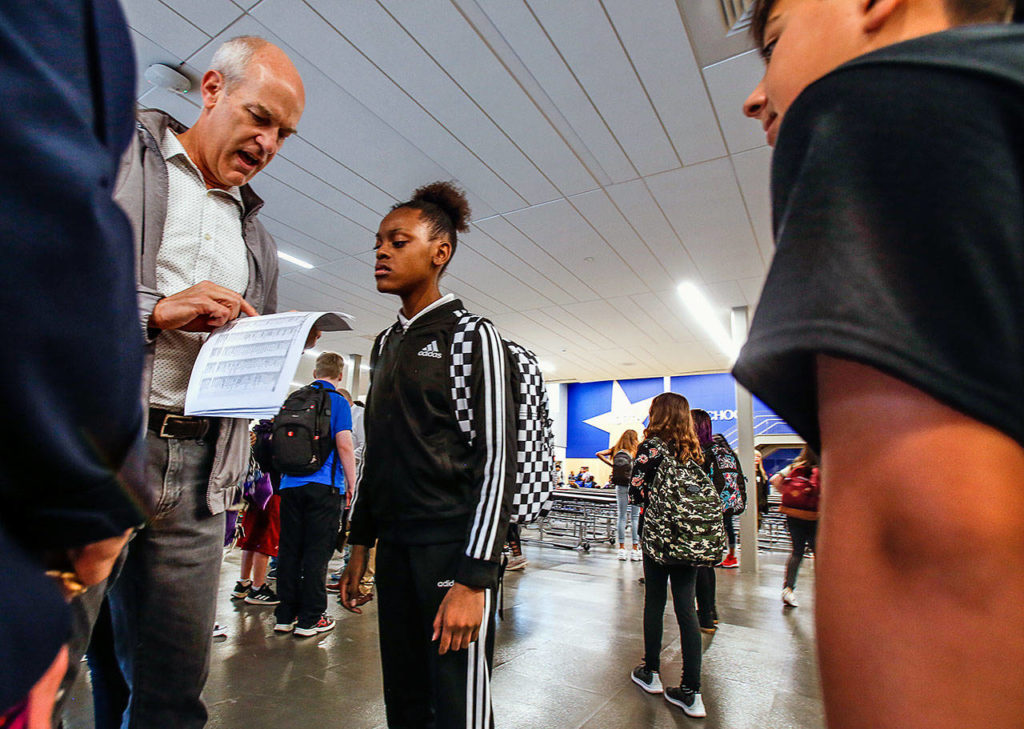 Congressman Rick Larsen helps students with room numbers and directions Wednesday morning as they arrive in the commons of the newly reconstructed North Middle School in Everett. (Dan Bates / The Herald)
