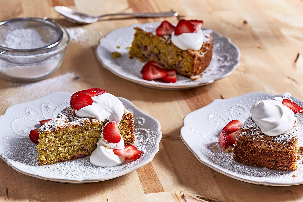 Top strawberry and pistachio olive oil cake with creme fraiche or yogurt and extra strawberries. (Stacy Zarin Goldberg / For The Washington Post)