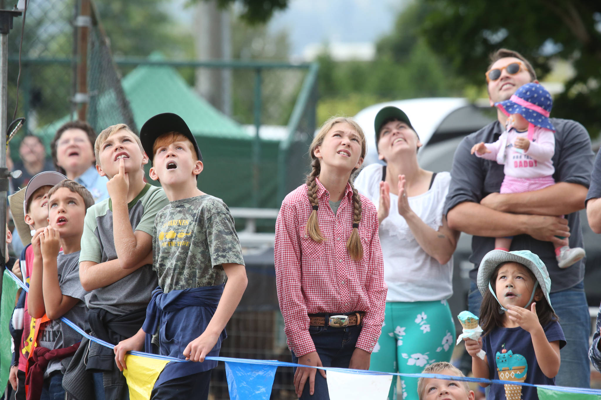 Kids watch as loggers climb 60 foot poles during the International Lumberjack Show on opening day of the Evergreen State Fair on Aug. 22 in Monroe. (Andy Bronson / The Herald)