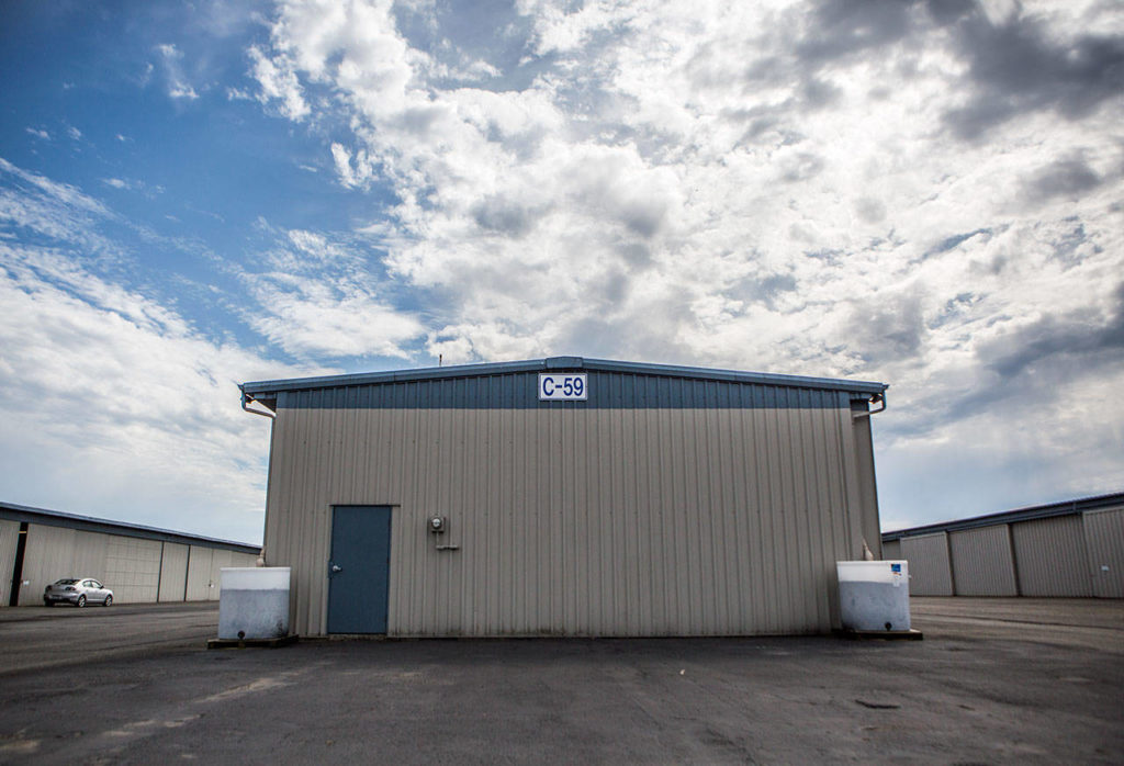 Two large containers sits next to a airplane hangar at to help filter rain water runoff from the roofs at Paine Field on Sept. 5 in Everett. (Olivia Vanni / The Herald)
