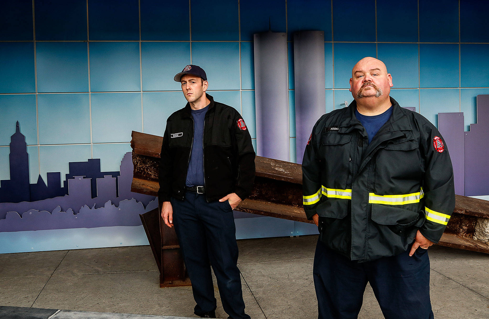 Arlington firefighter Aaron Boede, 30 (left), and acting Capt. Greg Koontz with a steel beam that was recovered from ground zero after the attacks of Sept. 11, 2001. A memorial display at Arlington’s Fire Station 46 is visible from the street and open to the public. (Dan Bates / The Herald)
