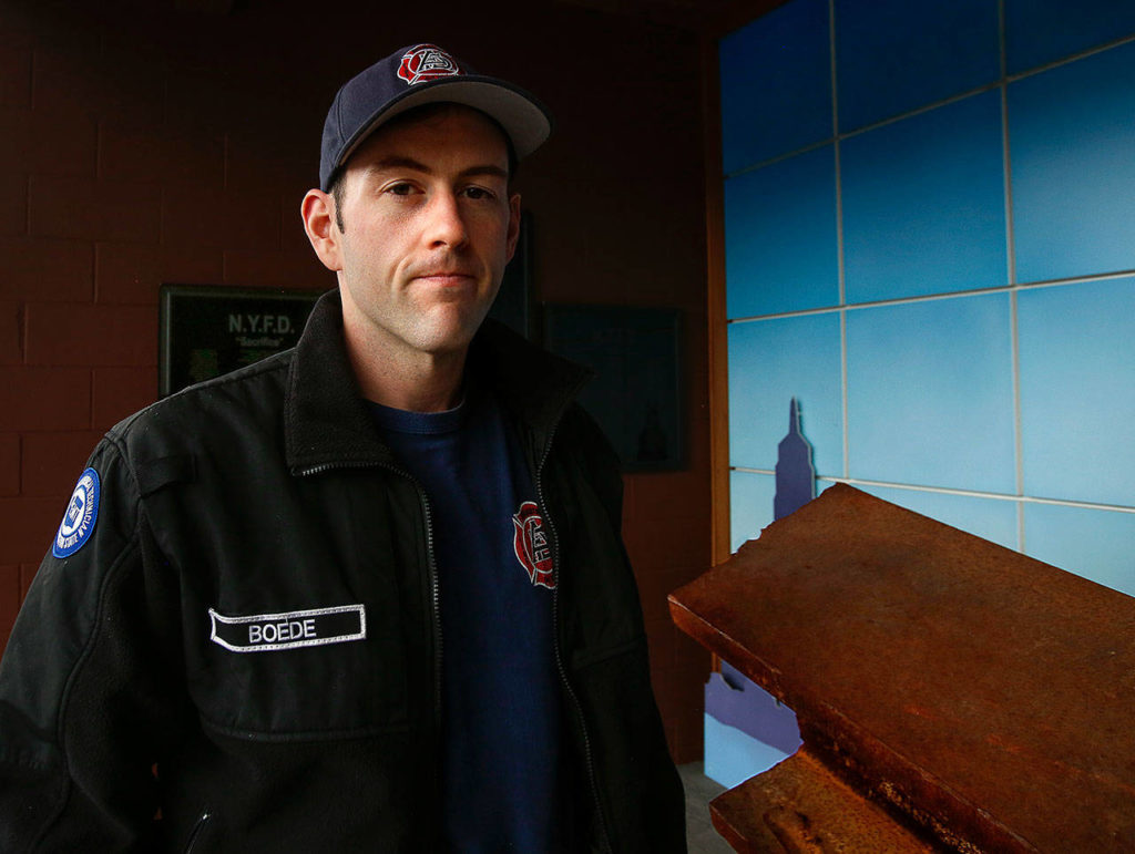 Aaron Boede, 30, near the Arlington Fire Department’s 9/11 memorial display at 137 N. Macleod Ave. (Dan Bates / The Herald)

