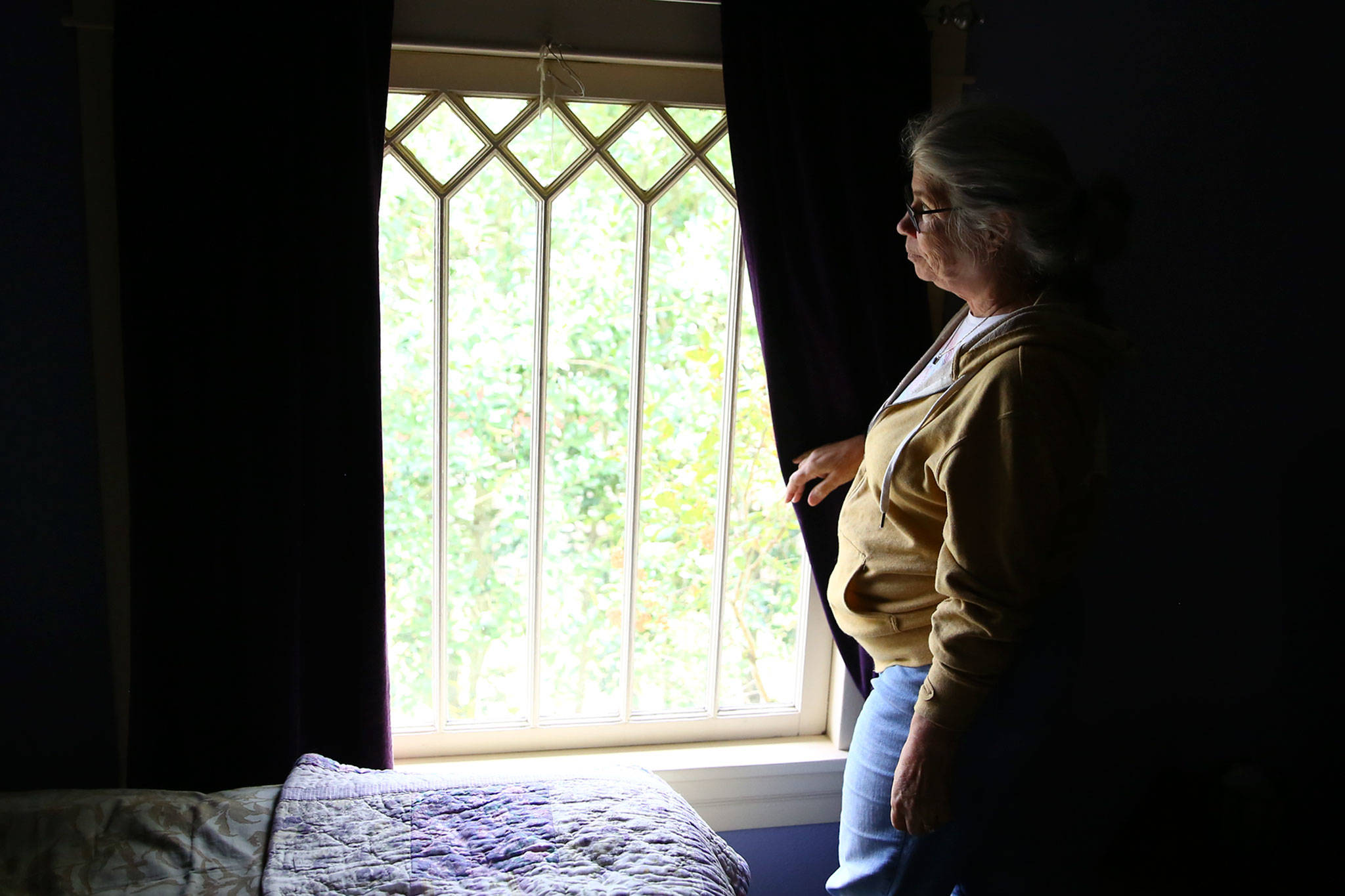 Susan Mausshardt looks out one of her home’s many original windows, likely dating from when it was built in 1909. (Kevin Clark / The Herald)