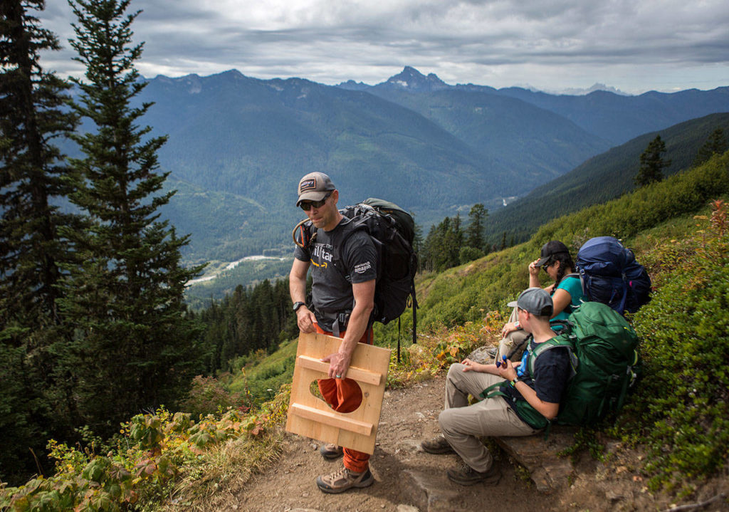 Don Sarver adjusts his grip on a toilet seat he is carrying up to Green Mountain Lookout for repairs as a part of his steward duties. (Olivia Vanni / The Herald)
