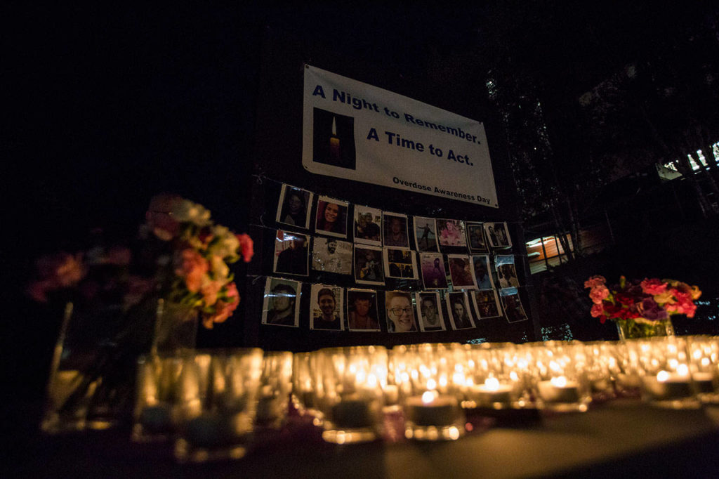 Candles sit in front of a remembrance board at Snohomish Overdose Prevention’s A Night to Remember on Thursday in Everett. (Olivia Vanni / The Herald)
