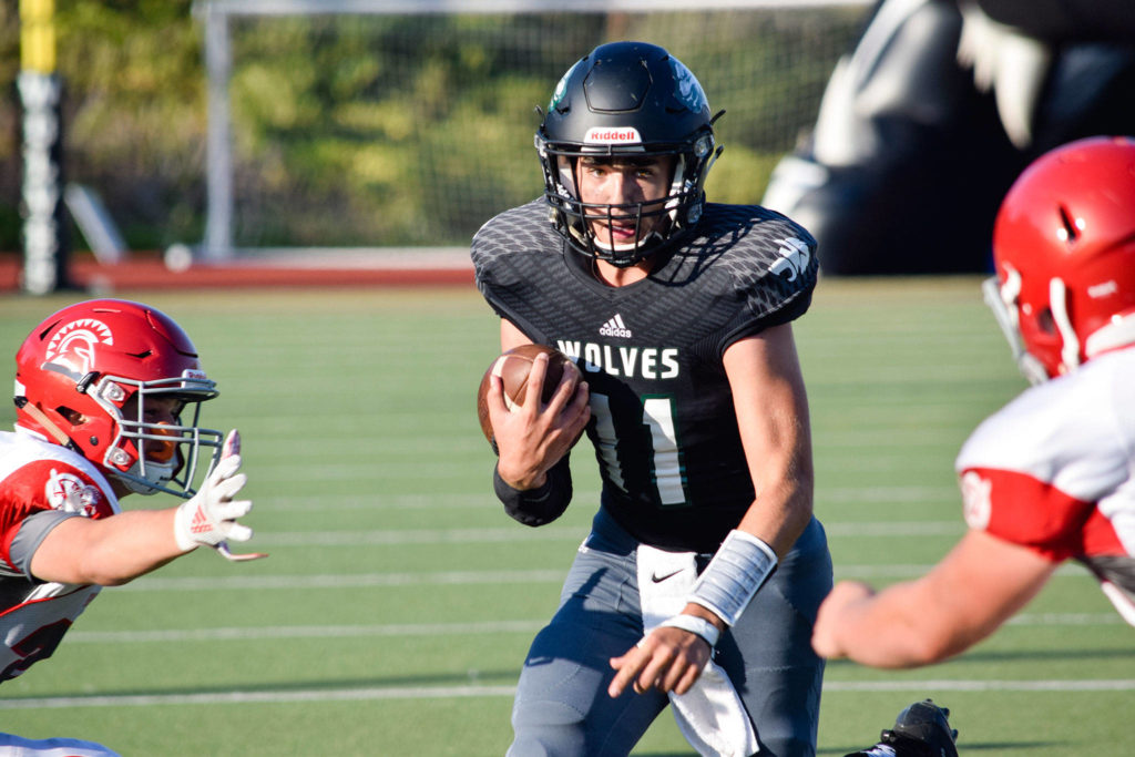 Junior quarterback Nathan Clark keeps the ball against Stanwood on Friday at Everett Memorial Stadium. (Katie Webber / The Herald)
